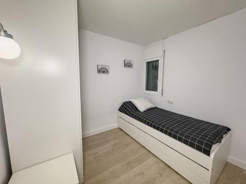 een kamer met een bed in een witte kamer bij Apartamento Marina Roses in Roses