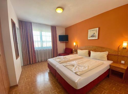 a hotel room with a large bed and a window at Hotel Gasthof Rose in Günzburg