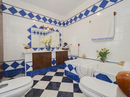 un bagno blu e bianco con vasca e servizi igienici di Cubo's Apartamento Gongora A & B ad Alhaurín el Grande