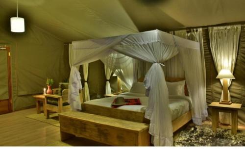 Un pat sau paturi într-o cameră la Dan Maasai Mara safari camp