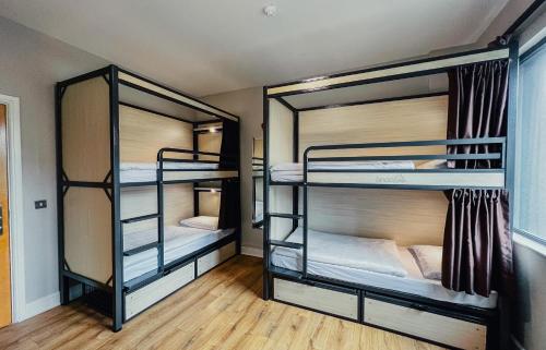 a room with three bunk beds in a room at Snoozles Galway City Centre in Galway