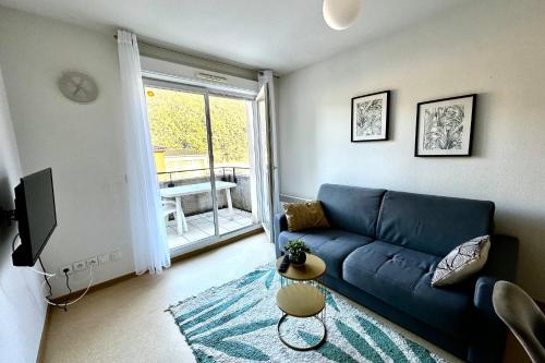 un salon avec un canapé bleu et une fenêtre dans l'établissement F26 Les Naïades- 1 bedroom for 4 people !, à Avène