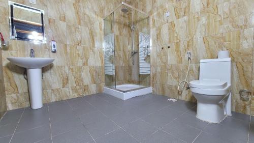 La salle de bains est pourvue de toilettes et d'un lavabo. dans l'établissement Comfort Inn Mbezi Beach, à Dar es Salaam