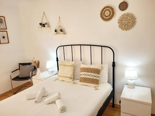 a bedroom with a bed with two white socks on it at Amélia Apartment - Peniche Surf Camp in Peniche