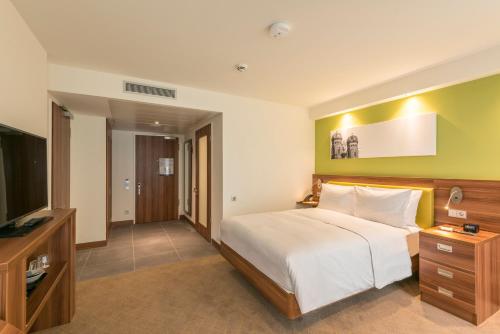 a bedroom with a bed and a flat screen tv at Hampton By Hilton Munich City West in Munich