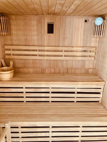 a room with a sauna with wooden floors and a clock at Les Fougères 12 personnes SPA/SAUNA in Le Tholy