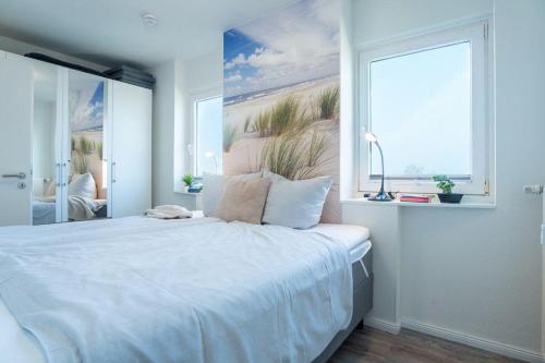 - une chambre avec un grand lit blanc et une fenêtre dans l'établissement Vier-Jahreszeiten-Haus-I-Wohnung-60, à Großenbrode
