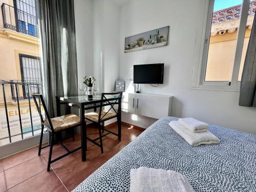 um quarto com uma cama, uma secretária e uma televisão em RC La Carihuela by Beehive Vacances em Torremolinos