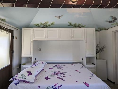 a bedroom with a bed with a white headboard at Theea's tiny house in Certeju de Sus