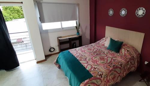 a red bedroom with a bed and a window at DEPARTAMENTO 1E REFUGIO DEL PARANA Alquiler ZONA PARQUE MITRE FACULTAD DE MEDICINA Y VETERINARIA in Corrientes