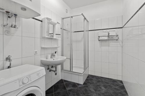 a white bathroom with a sink and a shower at StayEasy Apartments Krieglach W1 