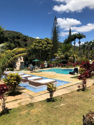 a swimming pool in a resort with trees and plants at Ytacaranha Hotel de Serra in Meruoca