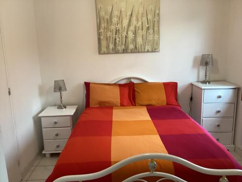 une chambre avec un lit coloré et deux tables de nuit dans l'établissement Riverside Gîte Pinel Hauterive, à Pinel-Hauterive