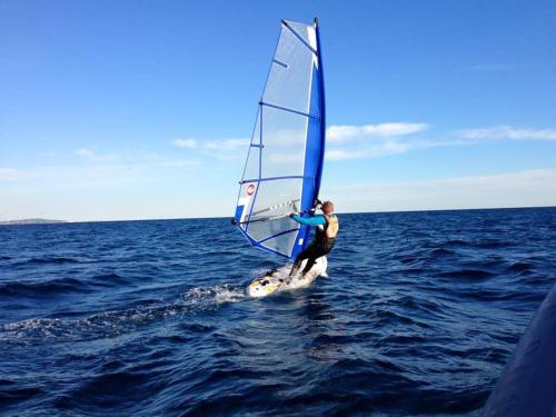 un homme sur un voilier dans l'eau dans l'établissement Studio Marina baie des Anges, 3 lits,clim, plages, à Villeneuve-Loubet