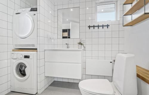 a white bathroom with a washing machine and a toilet at Cozy Home In Slagelse With Wifi in Slagelse
