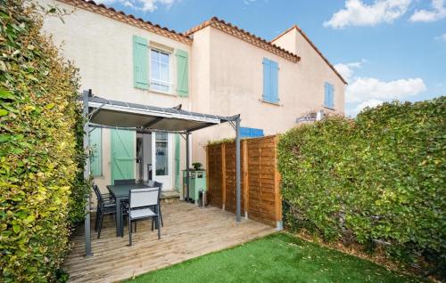 a patio with a table and chairs in front of a house at 2 Bedroom Cozy Home In Aigues-Mortes in Aigues-Mortes