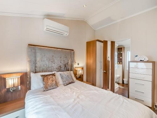 1 dormitorio con 1 cama grande con colcha blanca en Sea View Lodge, en Horden
