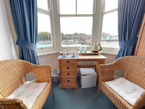 a room with two chairs and a table and a window at Seascape guest house in Melcombe Regis