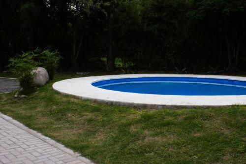 una pequeña piscina azul en un patio con una acera en Allende Suite Departamentos en Villa Allende