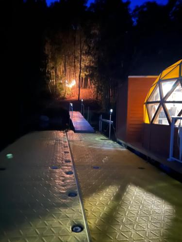 una vista notturna di una strada con un edificio illuminato di Sam’Relax Plus a Tracadie