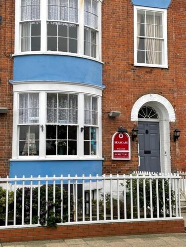 a blue house with a white fence in front of it at Seascape guest house in Melcombe Regis