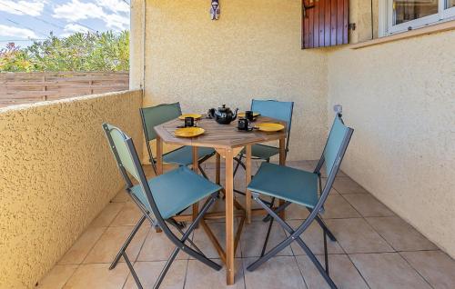 - une table en bois avec des chaises et un service à thé dans l'établissement 2 Bedroom Gorgeous Home In Serignan, à Valras-Plage