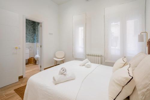 a white bedroom with a white bed with towels on it at 2 bedrooms 2 bathrooms furnished - Chamberi - modern - MintyStay in Madrid