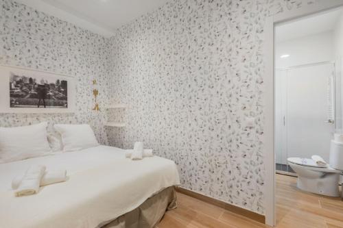 a white bedroom with a bed and a bathroom at 2 bedrooms 2 bathrooms furnished - Chamberi - modern - MintyStay in Madrid