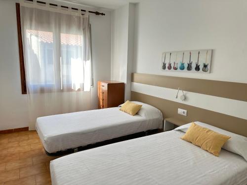 a room with two beds and a window at Agi Pere Lluis in Roses