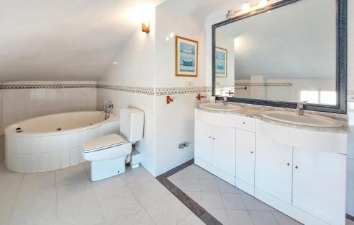 a bathroom with two sinks and a tub and a toilet at Stunning Apartment In Castell De La Plana With Kitchen in Castellón de la Plana