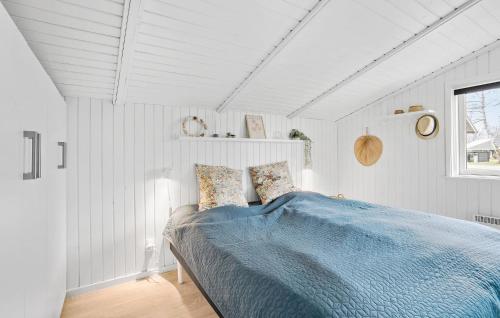 a bedroom with a bed with a blue blanket at 2 Bedroom Nice Home In Juelsminde in Juelsminde