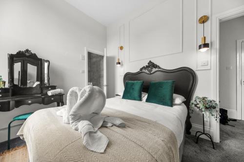 a bedroom with a bed with a towel animal on it at Pelican Suite 1 Bed Apartment in Harrogate