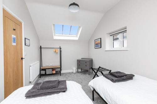a attic bedroom with two beds and a mirror at The Old Bakery Angmering in Angmering