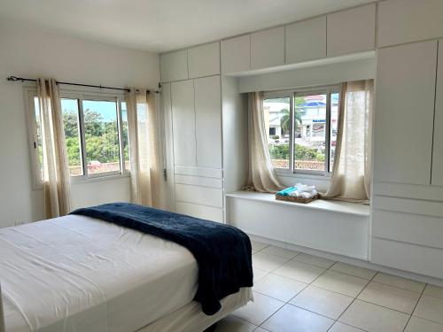 a bedroom with a bed and two windows at Luxury Simpson bay condo in Koolbaai