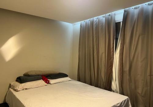 a bed with two pillows on it next to a window at Aeroporto Confins, 15min Belo-Horizonte, Cidade do Galo, Mega Space in Vespasiano