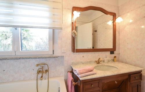 La salle de bains est pourvue d'une baignoire, d'un lavabo et d'un miroir. dans l'établissement 3 Bedroom Awesome Home In Bergamo, à Bergame