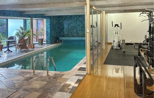 an indoor swimming pool with a gym with a treadmill and a room with a pool at Lovely Home In Nybrostrand With Sauna in Glemminge