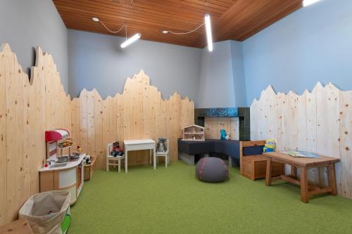 a room with wooden walls and green carpet at Randolins Familienresort in St. Moritz