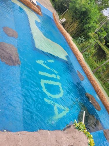a pool of blue water with the word pool painted on it at Sítio refúgio do lago in Piracicaba