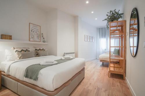 biała sypialnia z dużym łóżkiem i lustrem w obiekcie Amazing apartment-3Bedrooms 3Bathrooms-Lavapiés w Madrycie