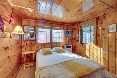 una camera con un letto in una cabina di legno di Rustic Laconia Studio Cabin about 2 Mi to Weirs Beach! a Laconia