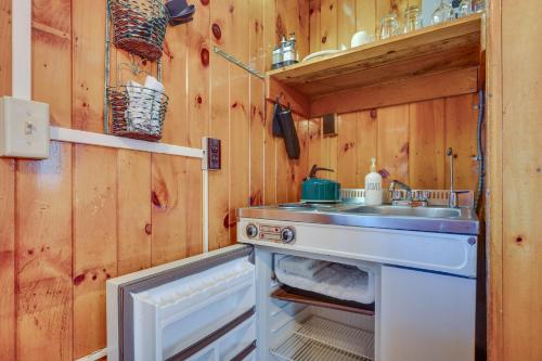 a small kitchen with a sink and a stove at Rustic Laconia Studio Cabin about 2 Mi to Weirs Beach! in Laconia