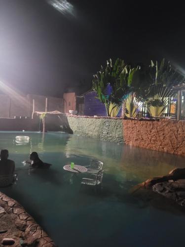 a person swimming in a swimming pool at night at Sítio refúgio do lago in Piracicaba