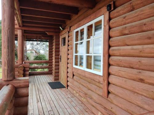 eine Holzhütte mit einem Fenster und einer Veranda in der Unterkunft Tapa Cottage next to disc golf. in Tapa