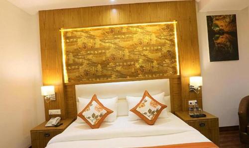 Una cama en una habitación de hotel con un cuadro encima. en FabHotel Prime Star 17 en Nueva Delhi