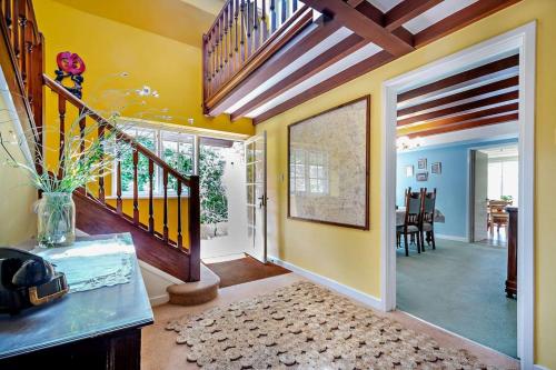 a living room with a staircase and aoyer with yellow walls at Spacious Cottage in the Centre of Burford, Cotswolds in Burford