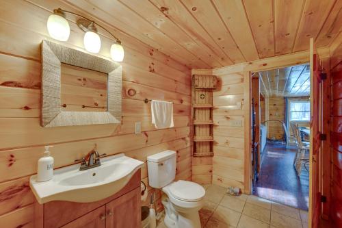 baño con aseo y lavamanos en una cabaña de madera en Cozy Laconia Cabin, Close to Winnipesaukee Pier! en Laconia