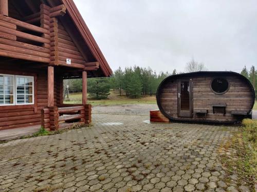 ein Blockhaus mit einer großen Tür an der Seite in der Unterkunft Tapa Cottage next to disc golf. in Tapa