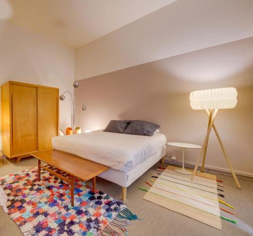 - une chambre avec un lit, une table et un tapis dans l'établissement Leyteire, à Bordeaux
