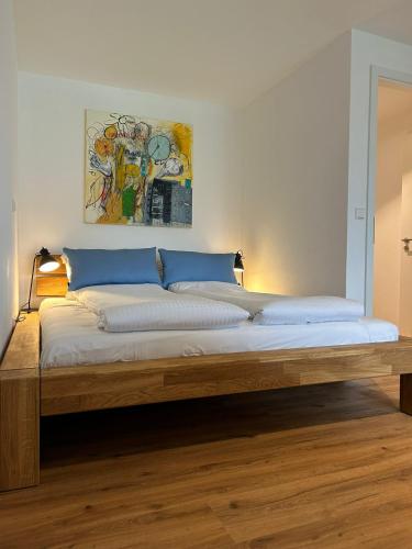 1 dormitorio con 1 cama grande con marco de madera en City Apartment mit TG Stellplatz - Glücks-Quartier Urban 01, en Pforzheim